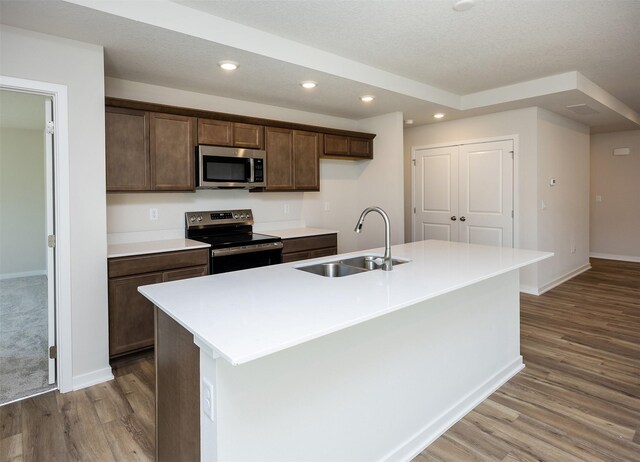 2228 Legacy Dr, Norwalk, IA 50211 - kitchen with stainless steel appliances, a sink, wood finished floors, baseboards, and recessed lighting