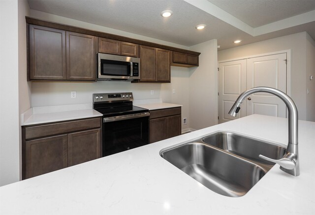 2228 Legacy Dr, Norwalk, IA 50211 - kitchen featuring appliances with stainless steel finishes, a sink, recessed lighting, and dark brown cabinets