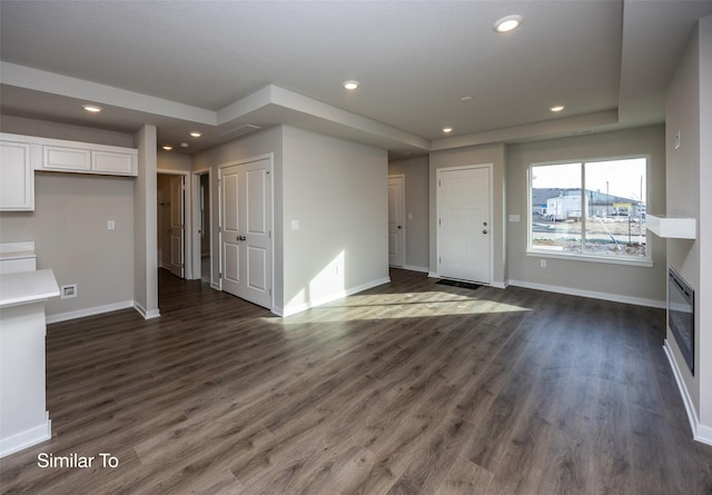 unfurnished living room with dark wood-type flooring