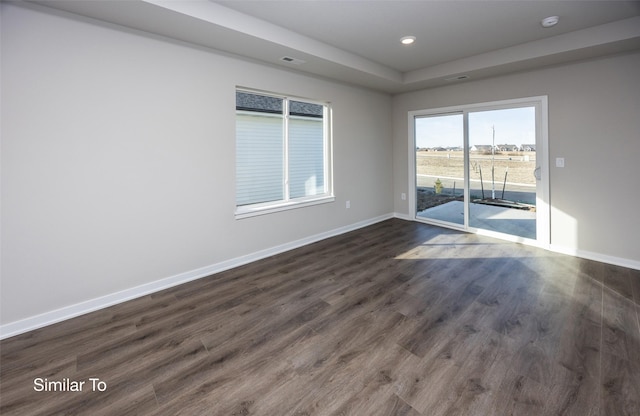 empty room featuring baseboards, visible vents, dark wood finished floors, and recessed lighting