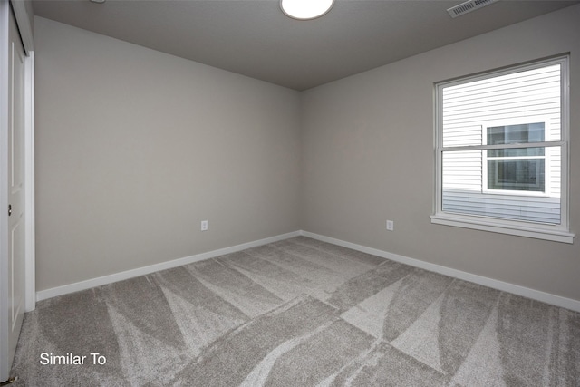 carpeted spare room with visible vents and baseboards