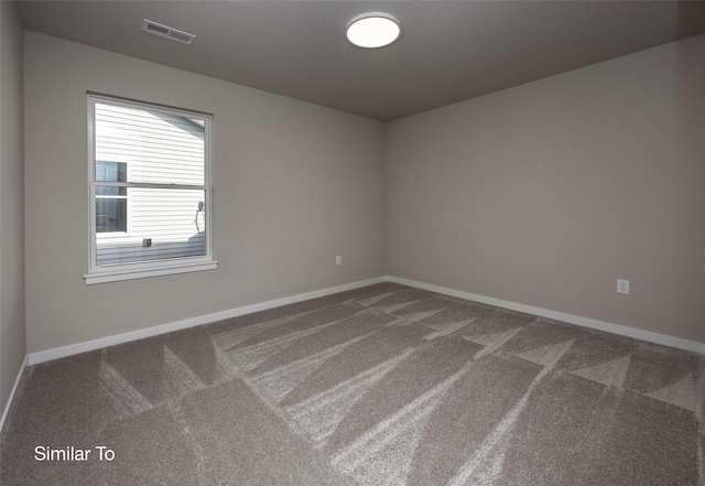 carpeted empty room featuring visible vents and baseboards