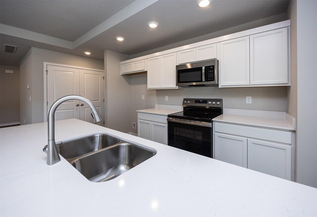 2232 Legacy Dr, Norwalk, IA 50211 - kitchen featuring stainless steel appliances, a sink, recessed lighting, white cabinets, and light countertops
