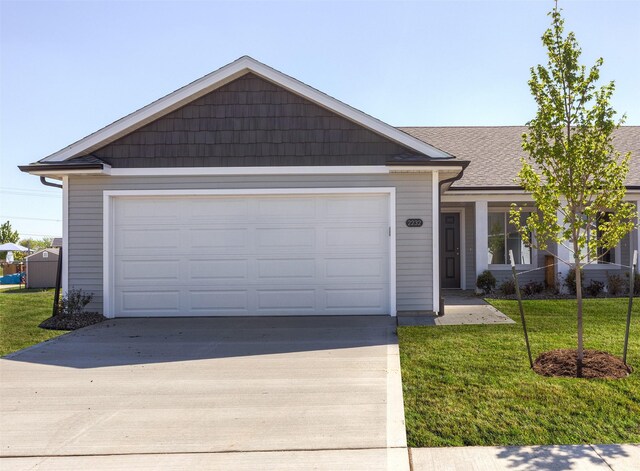 2232 Legacy Dr, Norwalk, IA 50211 - single story home with concrete driveway, a front yard, a garage, and roof with shingles