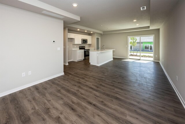 2232 Legacy Dr, Norwalk, IA 50211 - unfurnished living room with recessed lighting, baseboards, dark wood-style floors, and a sink
