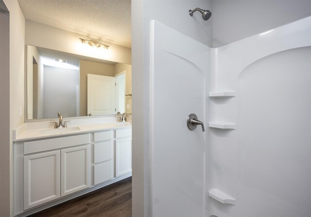 2232 Legacy Dr, Norwalk, IA 50211 - bathroom featuring wood finished floors, a shower, and double vanity