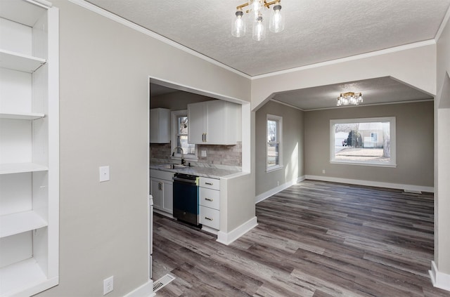 kitchen featuring sink, crown molding, an inviting chandelier, dark hardwood / wood-style floors, and black dishwasher