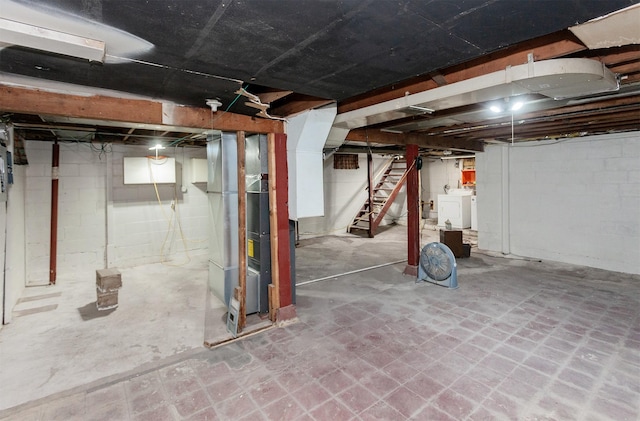 basement featuring heating unit and washing machine and dryer