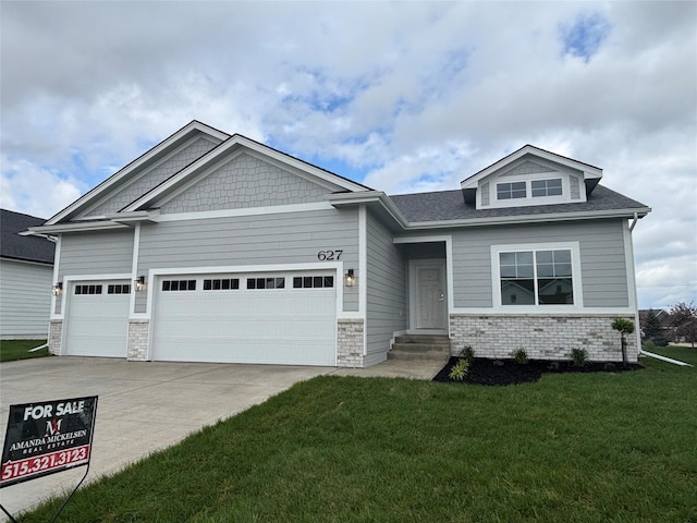 craftsman inspired home featuring a garage, concrete driveway, a front yard, brick siding, and entry steps