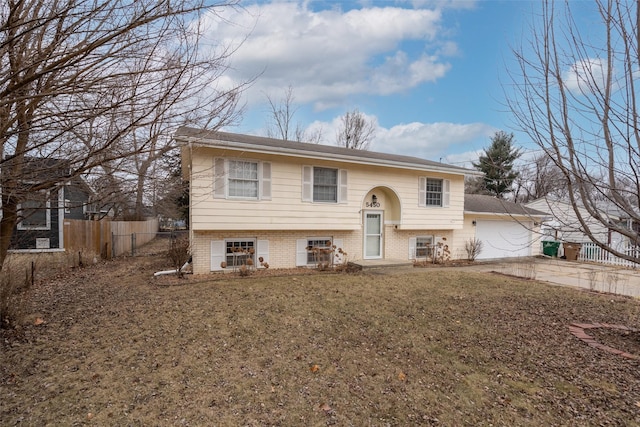 raised ranch featuring a garage and a front yard