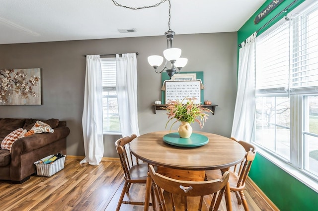 dining area with hardwood / wood-style floors and a chandelier