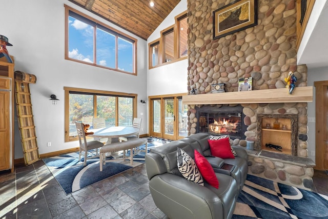 living room with a stone fireplace, wooden ceiling, and high vaulted ceiling