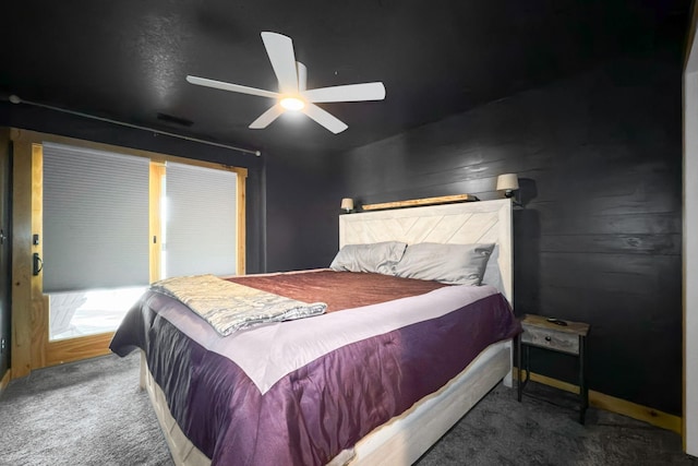 bedroom featuring ceiling fan and dark carpet