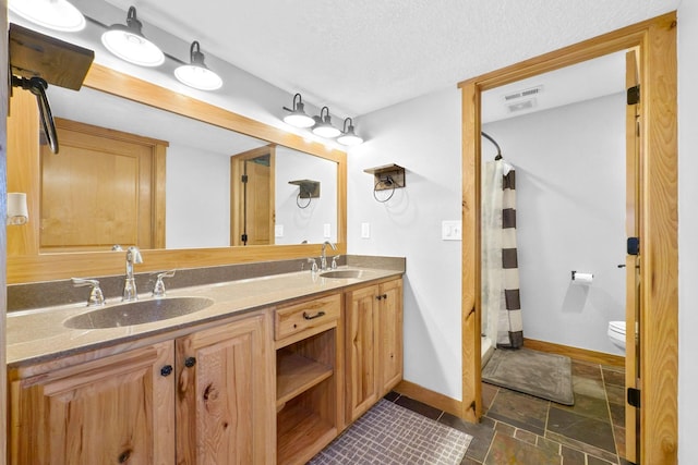 bathroom featuring vanity, toilet, a textured ceiling, and a shower with shower curtain