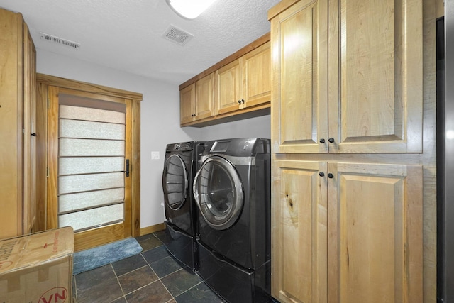 laundry area featuring cabinets, a textured ceiling, and independent washer and dryer