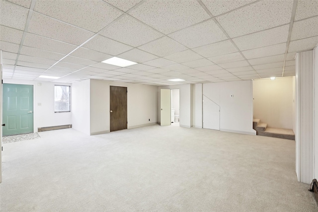 basement featuring light carpet and a paneled ceiling