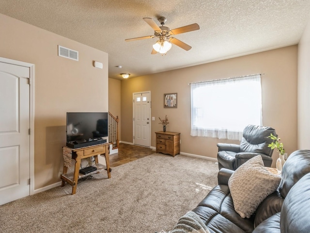 carpeted living room with ceiling fan and a textured ceiling