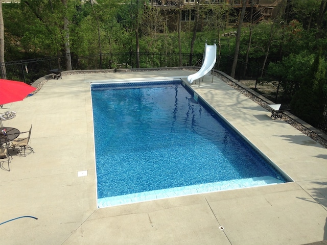 view of swimming pool with a patio and a water slide