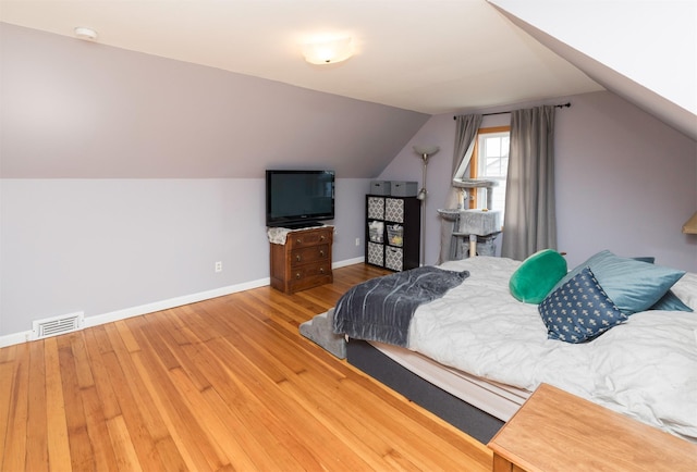 bedroom featuring hardwood / wood-style flooring and vaulted ceiling