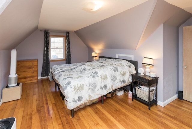 bedroom with hardwood / wood-style flooring and lofted ceiling