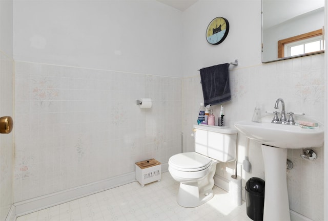 bathroom with toilet and tile walls