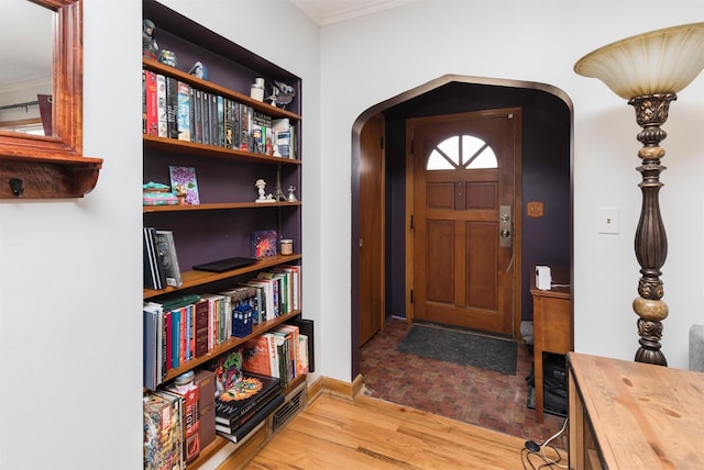 entrance foyer featuring crown molding and wood-type flooring