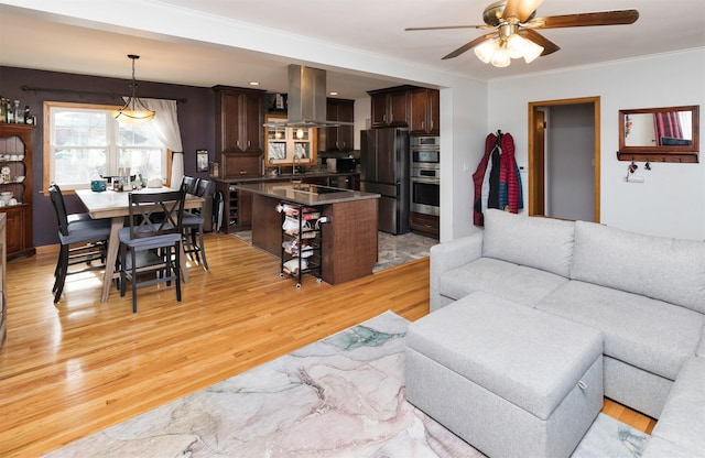 living room with ceiling fan, ornamental molding, sink, and light hardwood / wood-style flooring