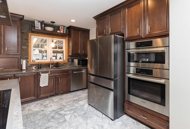 kitchen featuring stainless steel appliances, sink, hanging light fixtures, and dark stone counters