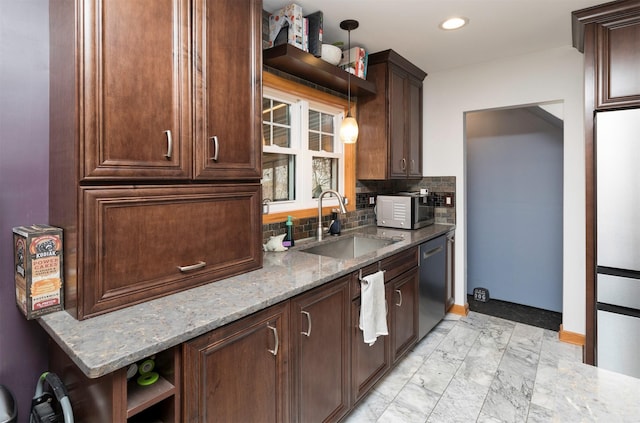 kitchen featuring sink, hanging light fixtures, stainless steel dishwasher, light stone countertops, and backsplash