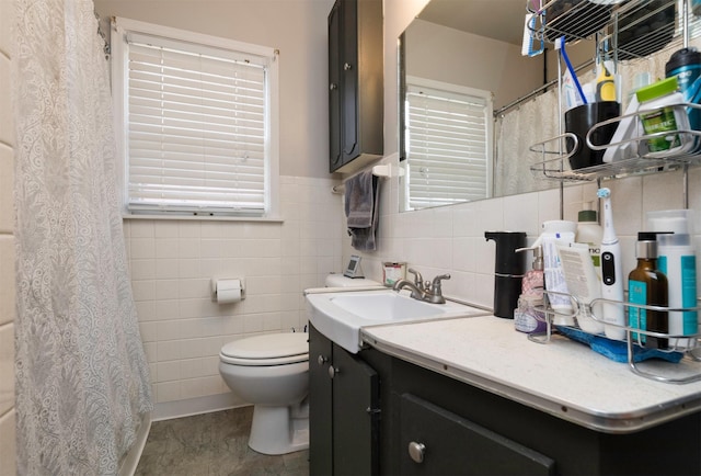 bathroom with vanity, tile walls, and toilet