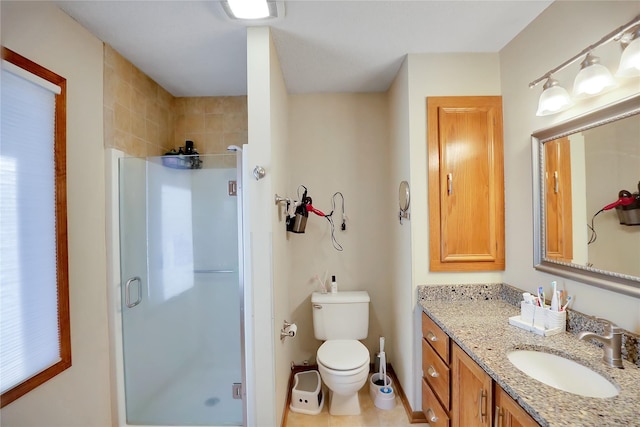 bathroom featuring vanity, toilet, and a shower with door