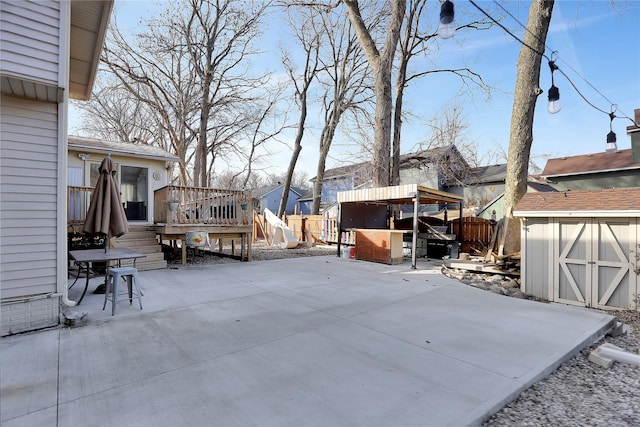 view of patio featuring a wooden deck and a shed