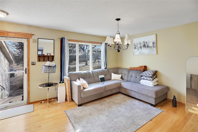 living room featuring hardwood / wood-style flooring, a chandelier, and a textured ceiling