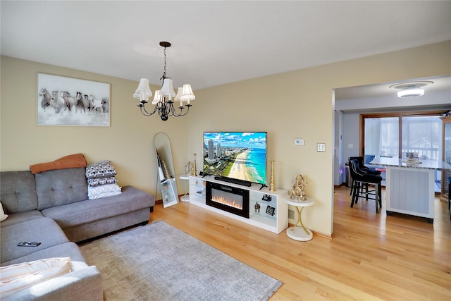 living room featuring an inviting chandelier and light hardwood / wood-style floors