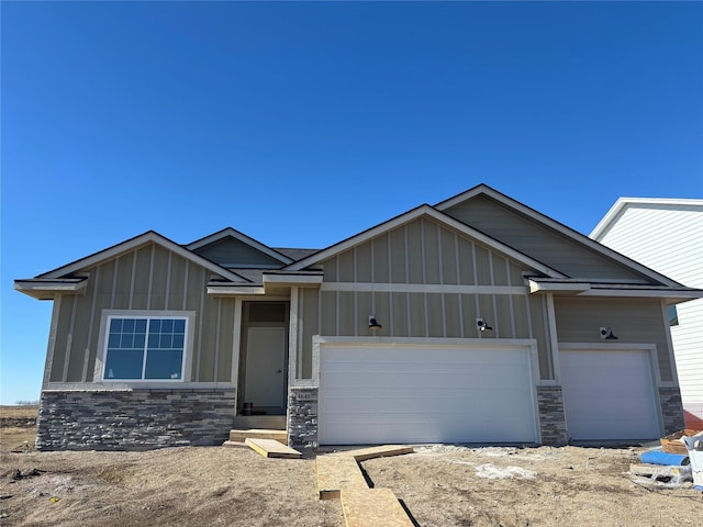 view of front of home featuring a garage, board and batten siding, and stone siding