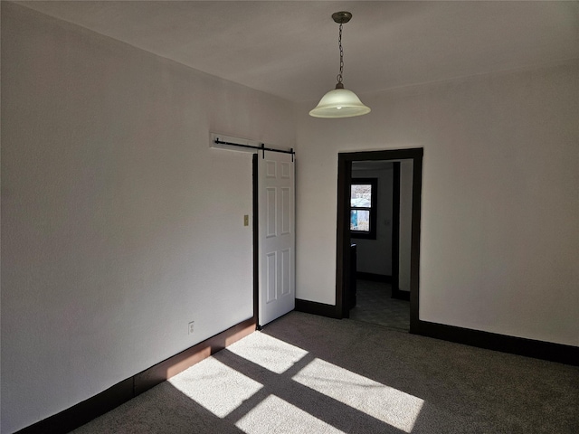 carpeted empty room featuring a barn door