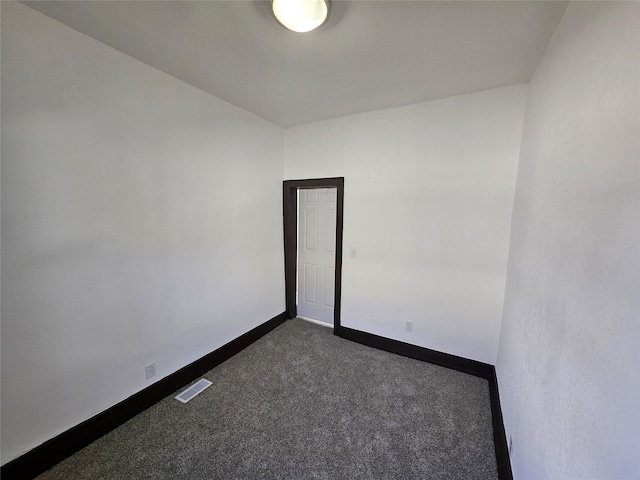 empty room featuring dark colored carpet