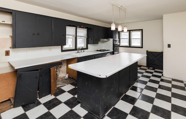 kitchen with hanging light fixtures, sink, a healthy amount of sunlight, and a kitchen island