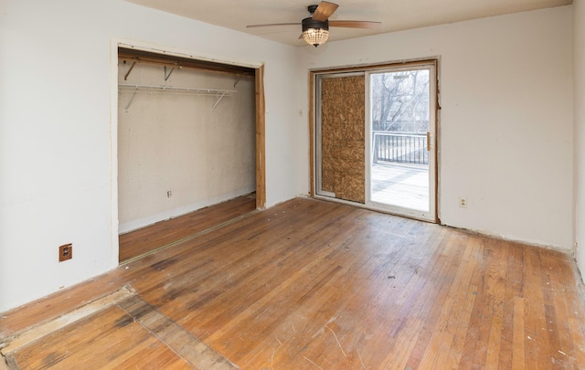 unfurnished bedroom with access to exterior, hardwood / wood-style flooring, a closet, and ceiling fan