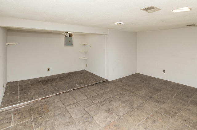 basement with electric panel and a textured ceiling