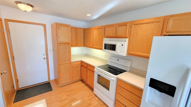 kitchen featuring white appliances and light hardwood / wood-style flooring