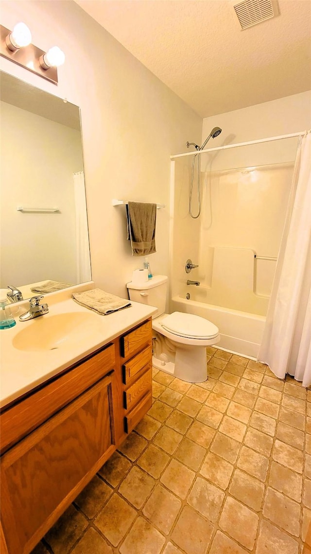 full bathroom with shower / tub combo with curtain, vanity, toilet, and a textured ceiling