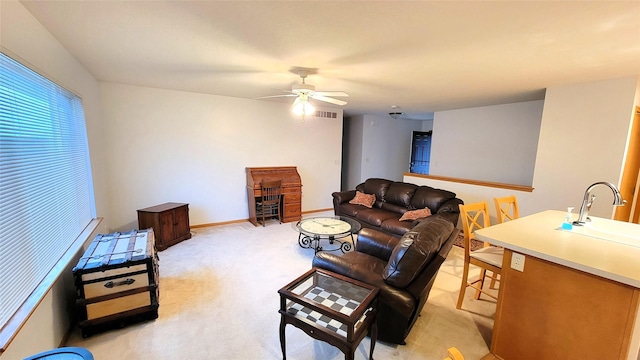 living room with sink, light carpet, and ceiling fan