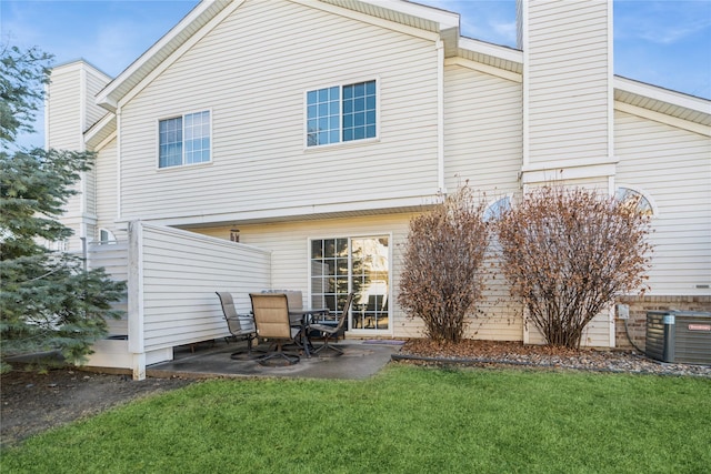 rear view of property featuring central AC, a yard, and a patio