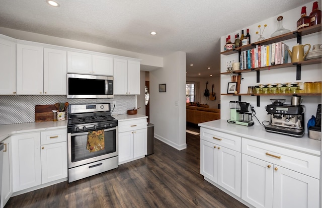 kitchen with white cabinetry, dark hardwood / wood-style floors, and appliances with stainless steel finishes