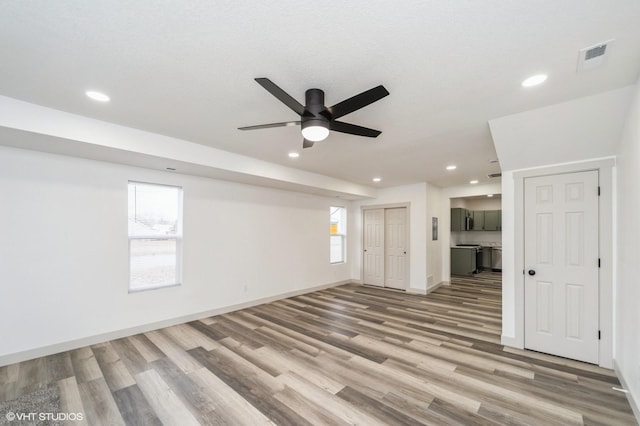 unfurnished living room featuring ceiling fan, light hardwood / wood-style flooring, and a healthy amount of sunlight