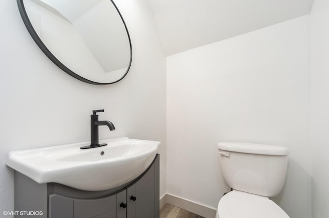 bathroom featuring vanity, hardwood / wood-style floors, and toilet