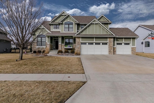 craftsman inspired home with a garage and a front yard