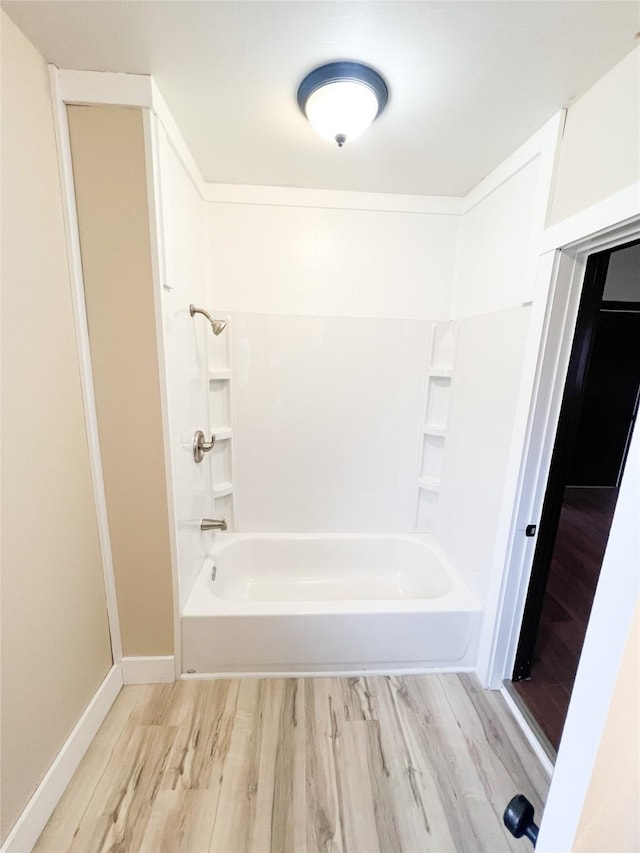 bathroom featuring wood-type flooring and shower / bathtub combination