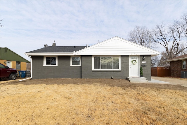 single story home with cooling unit and a front lawn